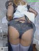 a woman in a black lingerie and stockings posing for the camera