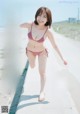 A woman in a red and white bikini running down a road.