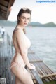 A woman in a pink bikini standing on a dock.