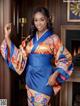 A woman in a blue and orange kimono posing for a picture.