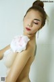 A woman is taking a bath with foam on her shoulder.