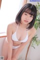 A woman in a white bikini posing for a picture.